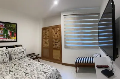 a bedroom with a bed and a desk and a television at exclusivo edificio con piscina en primera linea de playa in Cartagena de Indias