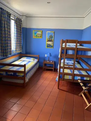 a bedroom with two bunk beds and a table at Condominio Playa Caimán in Coveñitas