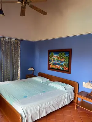 a bedroom with a large bed with a blue wall at Condominio Playa Caimán in Coveñitas