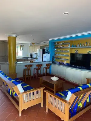 a living room with two benches and a kitchen at Condominio Playa Caimán in Coveñitas