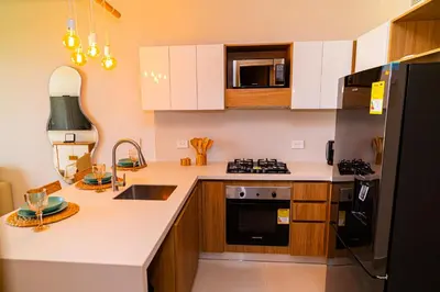 a kitchen with white cabinets and a black refrigerator at Exclusivo Apartamento en Baia Kristal 1 hab in Cartagena de Indias