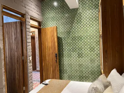 a bedroom with a bed and a green wall at Santa Isabel - Villa de diseño con vistas privilegiadas y piscina in Cartagena de Indias