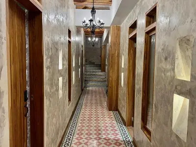 a hallway with a long corridor with wooden doors and a chandelier at Santa Isabel - Villa de diseño con vistas privilegiadas y piscina in Cartagena de Indias