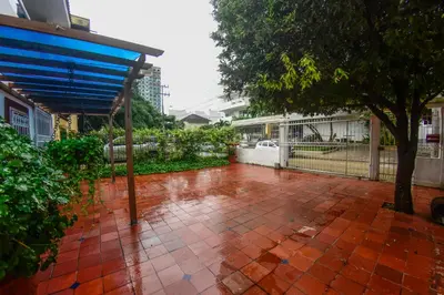 a red brick patio with a tree and a fence at Casa Hotel La Niña Neyla in Cartagena de Indias