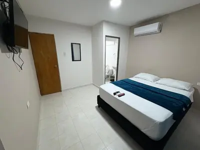 a bedroom with a large bed with a blue blanket at Hotel Stay Golden in Cartagena de Indias