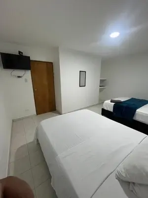 a hotel room with two beds and a television at Hotel Stay Golden in Cartagena de Indias