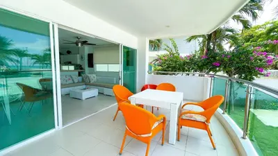 a balcony with orange chairs and a table on a patio at Hermoso Apartamento Frente al Mar 3 Habitaciones TR12 in Coveñitas