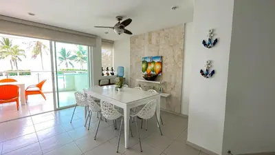 a dining room with a white table and chairs at Hermoso Apartamento Frente al Mar 3 Habitaciones TR12 in Coveñitas