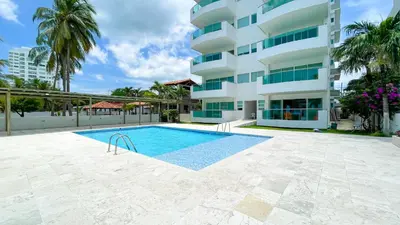a swimming pool in front of a building at Hermoso Apartamento Frente al Mar 3 Habitaciones TR12 in Coveñitas