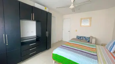a bedroom with a bed and a large black cabinet at Hermoso Apartamento Frente al Mar 3 Habitaciones TR12 in Coveñitas