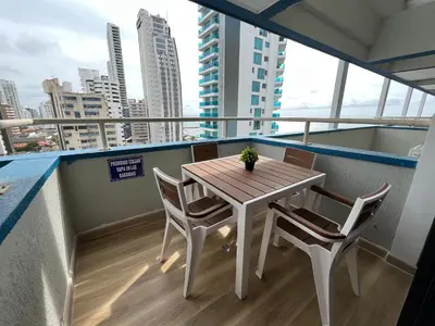 a table and chairs on a balcony with a view of a city at Portofino Bocagrande 3 habitaciónes in Cartagena de Indias