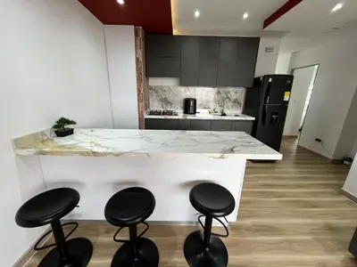 a kitchen with a counter with four stools around it at Portofino Bocagrande 3 habitaciónes in Cartagena de Indias