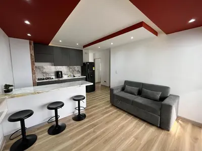 a living room with a couch and a kitchen at Portofino Bocagrande 3 habitaciónes in Cartagena de Indias