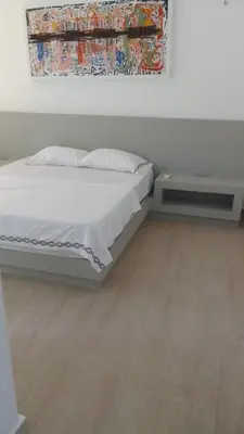 a bedroom with a white bed and a table at Edificio Mares de Coveñas in Coveñas