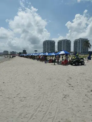 a group of blue umbrellas and tables on a beach at Edificio CH1 A UNOS PASOS DE LA PLAYA in Cartagena de Indias