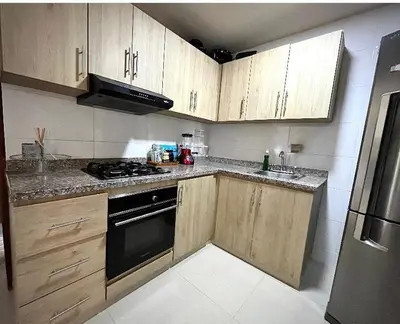 a kitchen with wooden cabinets and a stove top oven at Apartamento Cartagena cerca a la playa in Cartagena de Indias