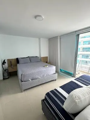 a bedroom with two beds and a large window at Amazing Beachfront Apartment in Cartagena de Indias