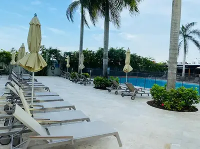 a row of lounge chairs and umbrellas next to a pool at Amazing Beachfront Apartment in Cartagena de Indias