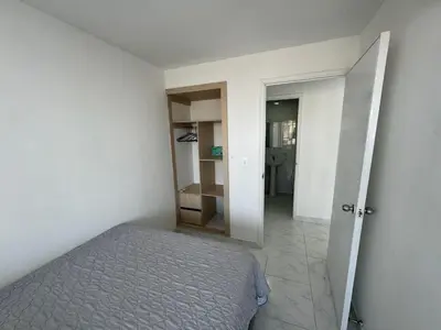 a bedroom with a bed and a door to a hallway at Portofino Bocagrande 2 habitaciones in Cartagena de Indias