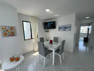 a dining room with a white table and chairs at Portofino Bocagrande 2 habitaciones in Cartagena de Indias