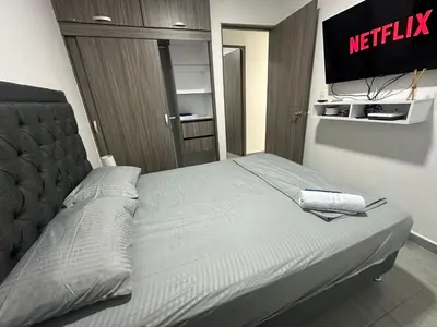 a bed in a room with ametisk sign on the wall at 3BR AC LUXURY APARTMENT CLOSE TO THE AIRPORT Beach & THE HISTORIC CENTER in Cartagena de Indias