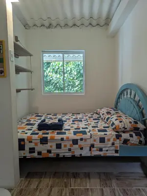 a bedroom with a bed with a blue headboard and a window at Casa Victoria in San Onofre