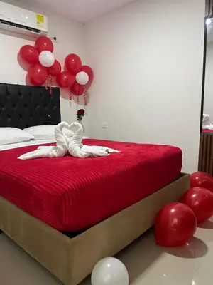 a bedroom with a bed with red sheets and balloons at Hostel HA1 in Cartagena de Indias