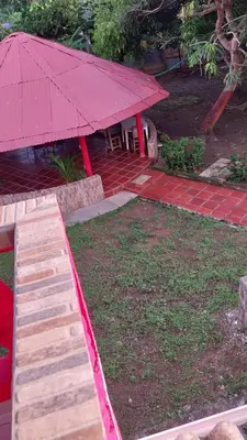 a picnic table with a red umbrella on a patio at Cabaña Villa Gabi in San Antero