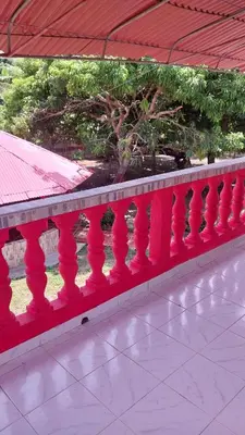 a red railing on a balcony of a building at Cabaña Villa Gabi in San Antero