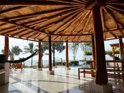 a wooden pavilion with a hammock and a view of the ocean at La Mofa Beach House in Bocachica