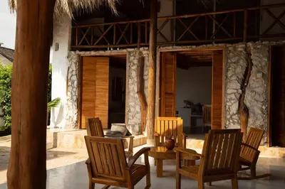 a patio with chairs and a table and a house at La Mofa Beach House in Bocachica
