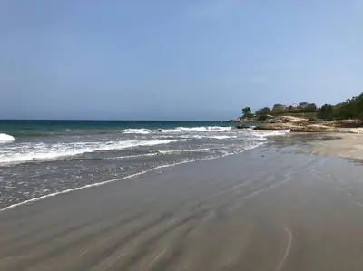 a sandy beach with waves in the ocean at La Mofa Beach House in Bocachica