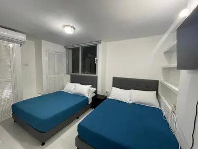 two beds in a small room with blue sheets at Espectacular apartamento de 4 alcobas en el Laguito in Cartagena de Indias