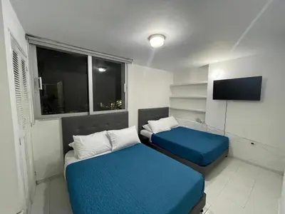 a small room with two beds and a television at Espectacular apartamento de 4 alcobas en el Laguito in Cartagena de Indias