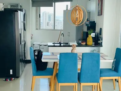 a kitchen with a table with blue chairs and a refrigerator at Apto 2301 vista al mar Palmetto elíptic in Cartagena de Indias