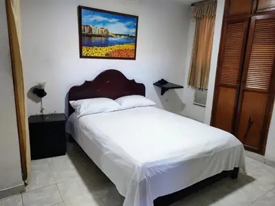 a bedroom with a bed and a picture on the wall at Hotel Tamaulipas Mixteca in Sincelejo