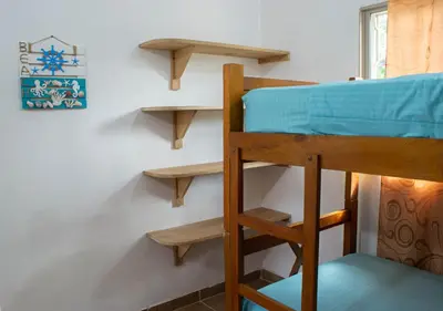a bunk bed in a room with a wall at Alojamiento Familiar #3 - Un terruño en la costa in Puerto Viejo