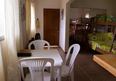 a dining room with a table and chairs and a bedroom at Alojamiento Familiar #4 - El mejor mar y playas in Puerto Viejo