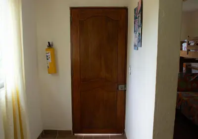 a wooden door in the corner of a room at Alojamiento Familiar #4 - El mejor mar y playas in Puerto Viejo