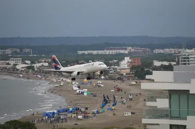 an airplane is flying over a beach with people at Cartagena Aparta Suite Crespo Aeropuerto in Cartagena de Indias