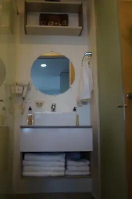 a bathroom with a sink and a mirror and towels at Cartagena Aparta Suite Crespo Aeropuerto in Cartagena de Indias
