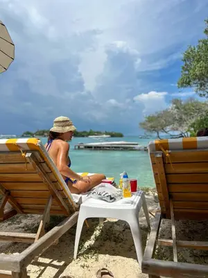 a young boy sitting in a chair on the beach at Casa Rosario in Isla Grande