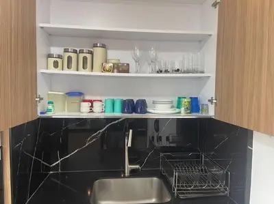 a kitchen with a sink and a shelf with dishes at Confort en el norte de la ciudad in Ciudad Jardín