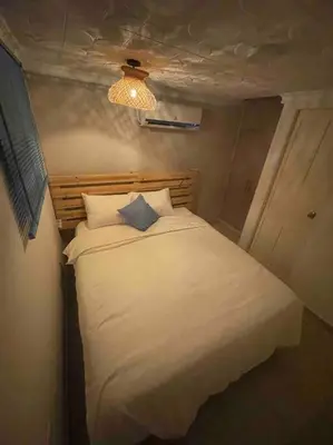 a small bedroom with a white bed and a light at Beautiful house en el centro in Cartagena de Indias