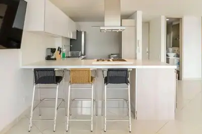 a kitchen with a white counter with bar stools at Playa Mar in Cartagena de Indias