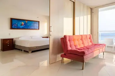 a bedroom with a red couch and a bed at Playa Mar in Cartagena de Indias