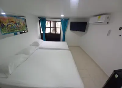 a bedroom with a white bed and a window at Hostal Doña Betty 2 in Cartagena de Indias