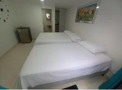 a bedroom with two white beds in a room at Hostal Doña Betty 2 in Cartagena de Indias
