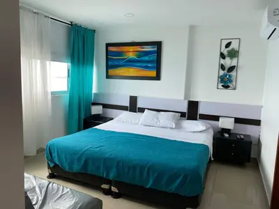 a bedroom with a large bed with a blue blanket at Apartamento Palmetto en Cartagena Vista al mar 702 in Cartagena de Indias
