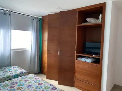 a bedroom with a bed and a cabinet with a television at Apartamento Palmetto en Cartagena Vista al mar 702 in Cartagena de Indias
